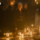 Queen Rhaenyra stands over a large map of Westeros which many candles have been placed upon.